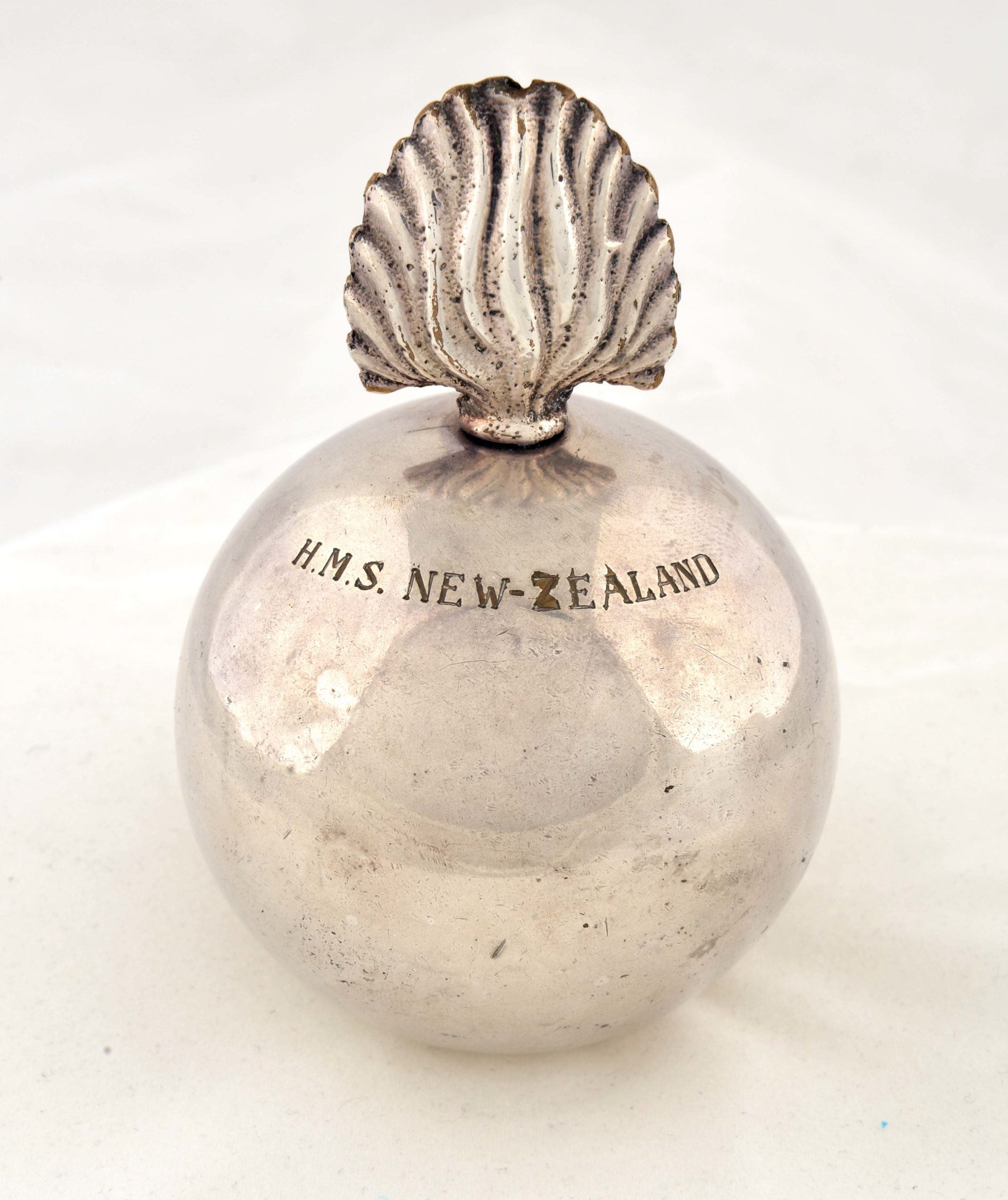 Silver lighter shaped like a grenade. Engraved are the words ‘HMS NEW ZEALAND‘.
