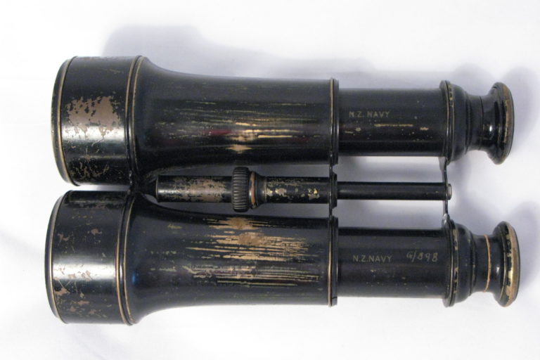 IBB-0003-Binoculars1 Binoculars complete with brown leather case. Glasses have no manufactures mark but each barrel is marked: ‘NZ Navy’. Case was made by George Bussey & Co. Ltd 1917.