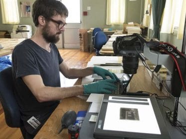Josh Windsor from the Auckland War Memorial Museum digitising a glass plate.