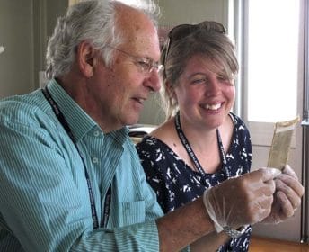 Paul Restall, Navy Museum Photo Archivist and Caroline Ennen, Navy Museum Collection Assistant, examine a glass plate.
