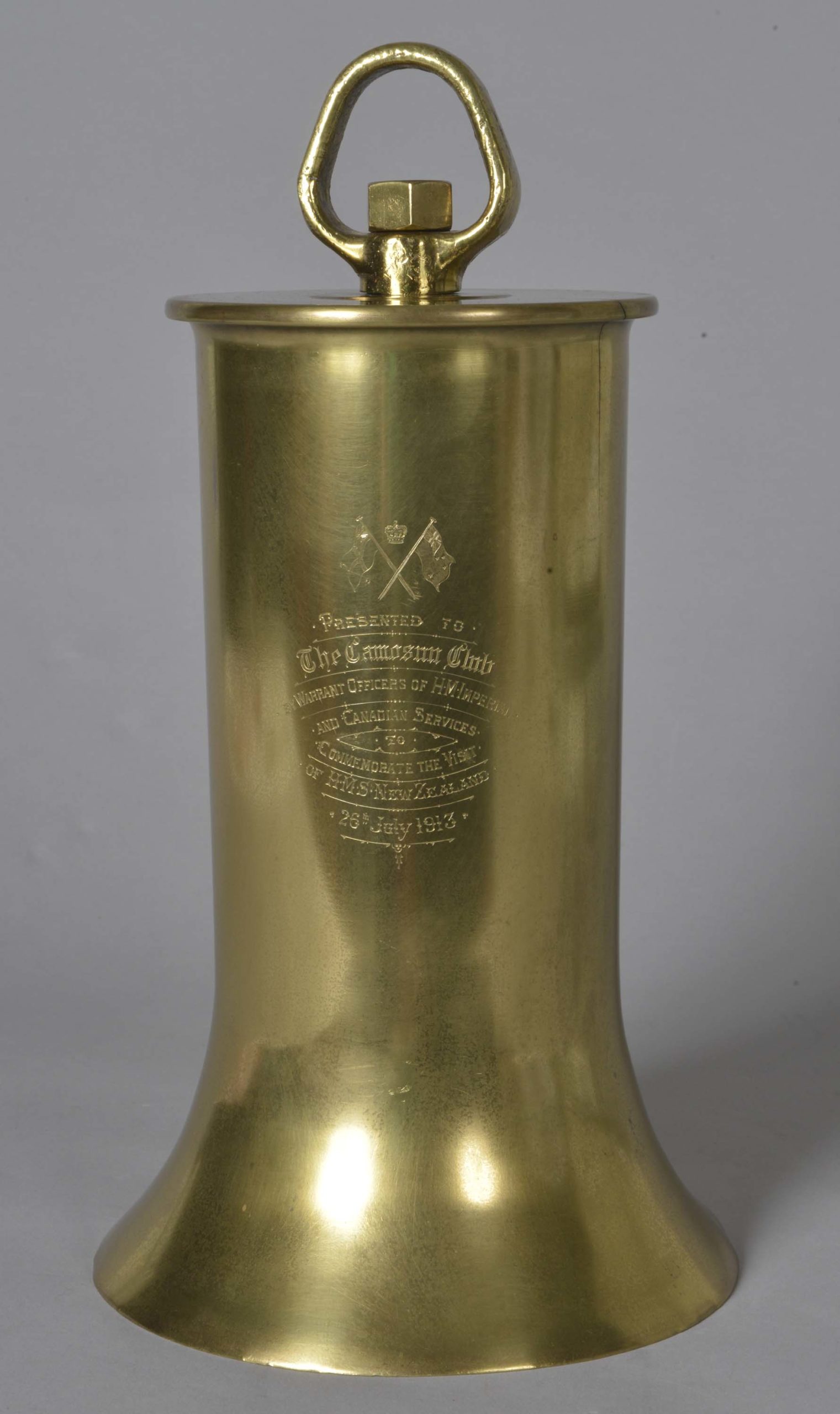 Brass presentation bell with clapper. Bell given to the Camosun Club of Victoria, British Colombia, by the Warrant Officers of HMS New Zealand. Inscribed on the bell are the words: ‘Presented to The Camosun Club by Warrant Officers of HM Imperial and Canadian Services to Commemorate the Visit of HMS New Zealand 26th July 1913’.